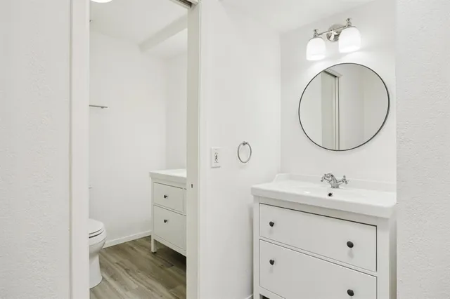 a bathroom with a sink mirror vanity and toilet