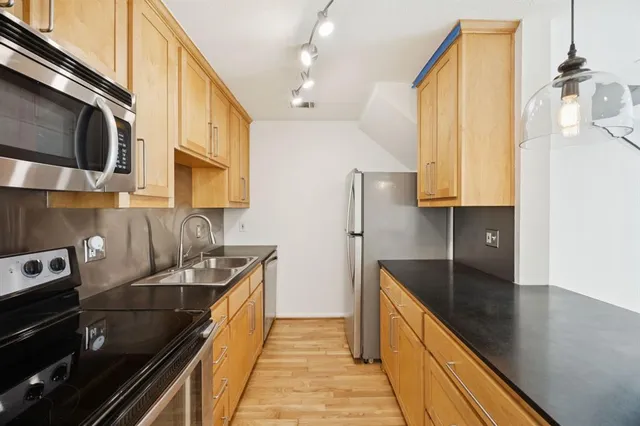 a kitchen with stainless steel appliances a sink a stove and cabinets