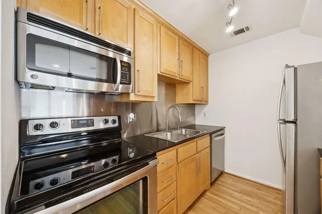 a kitchen with stainless steel appliances a stove a microwave and cabinets