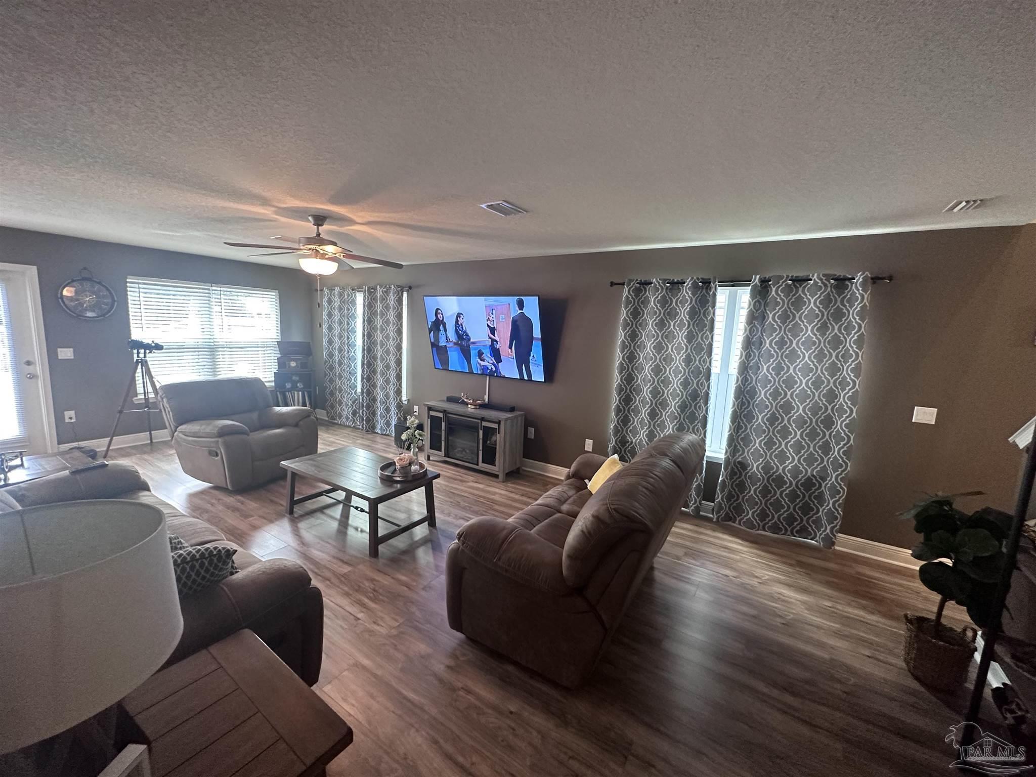 5217 Saufley Field Road Pensacola, FL 32526 - Photo 3 of 26 a living room with furniture and a flat screen tv