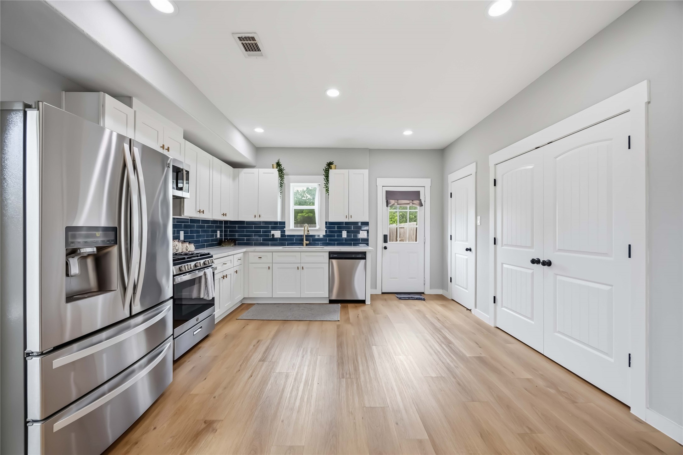 5403 Amy Street Houston, TX 77028 - Photo 4 of 28 a kitchen with white cabinets and stainless steel appliances