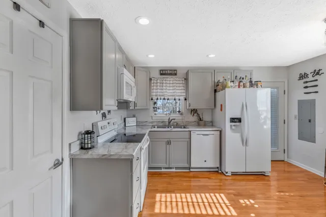 a kitchen with white cabinets and white appliances