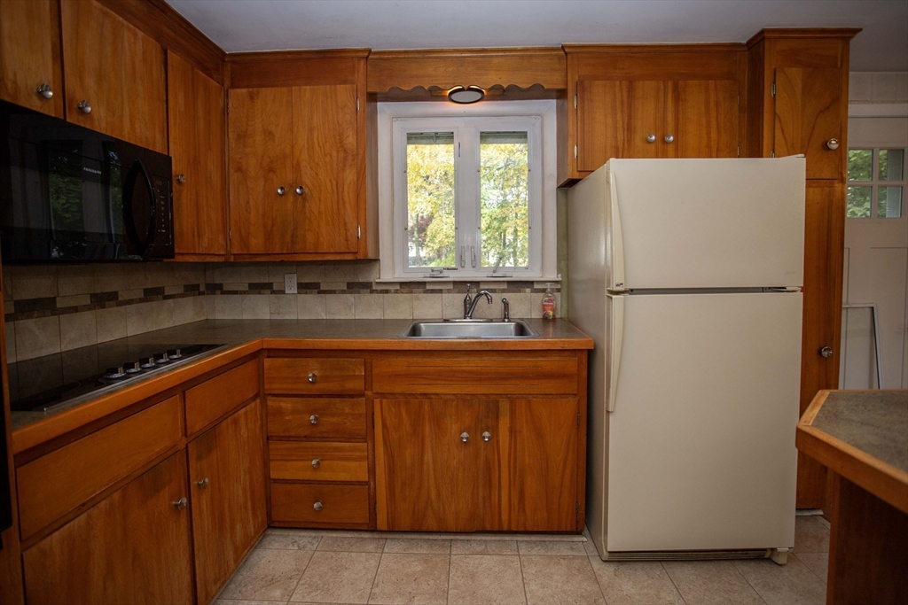 14 Sycamore Road Wakefield, MA 01880 - Photo 14 of 42 a white refrigerator freezer sitting in a kitchen