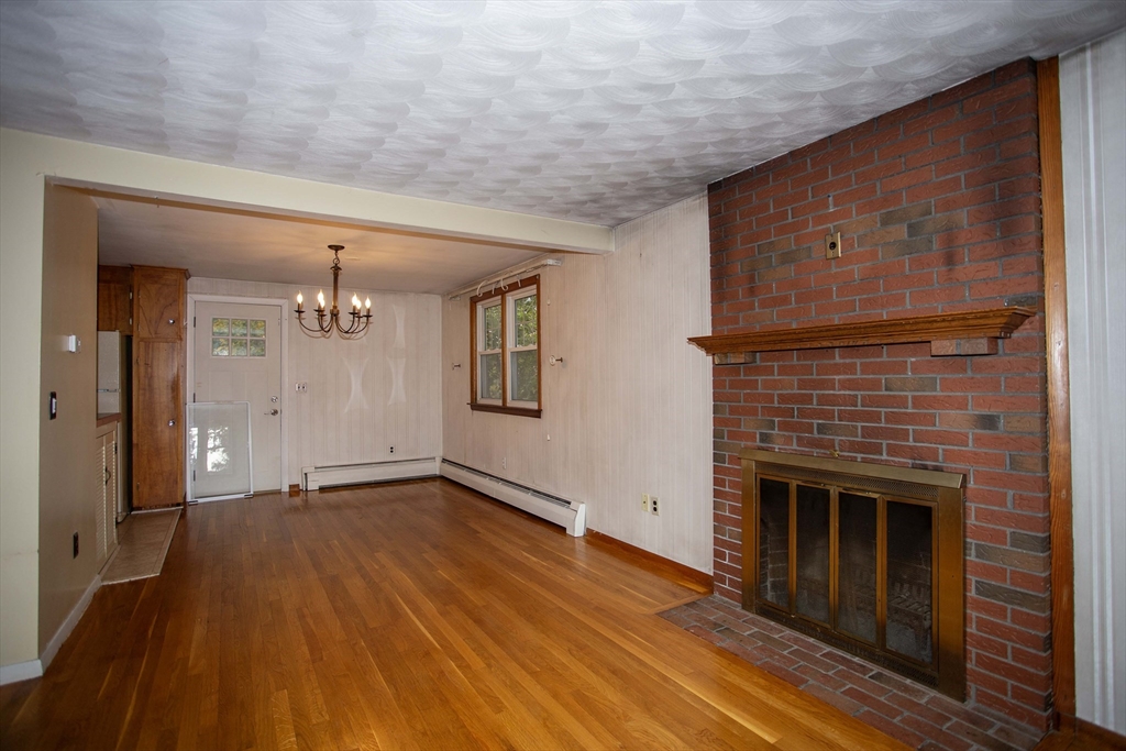 14 Sycamore Road Wakefield, MA 01880 - Photo 6 of 42 an empty room with wooden floor fireplace and windows