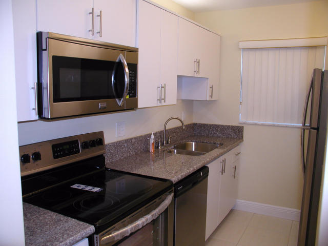 762 High Point Boulevard North, Unit D Delray Beach, FL 33445 - Photo 15 of 43 a kitchen with a sink stove and microwave