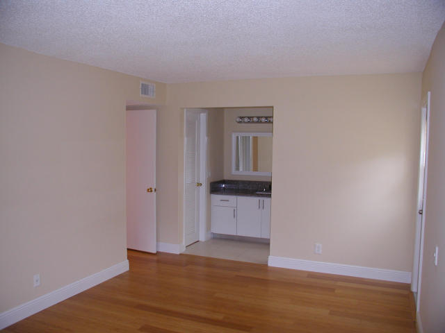 762 High Point Boulevard North, Unit D Delray Beach, FL 33445 - Photo 17 of 43 a view of empty room with wooden floor and kitchen