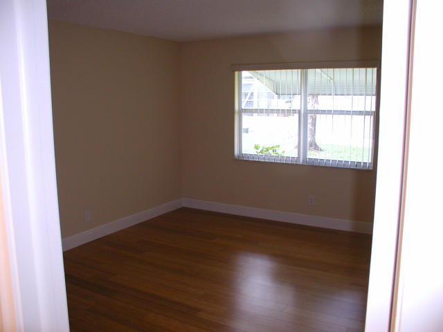 762 High Point Boulevard North, Unit D Delray Beach, FL 33445 - Photo 18 of 43 an empty room with wooden floor and windows