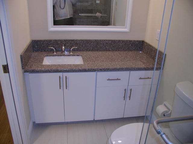 762 High Point Boulevard North, Unit D Delray Beach, FL 33445 - Photo 21 of 43 a bathroom with a granite countertop sink and a mirror