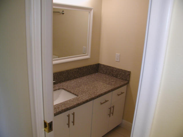 762 High Point Boulevard North, Unit D Delray Beach, FL 33445 - Photo 27 of 43 a bathroom with a granite countertop sink and vanity