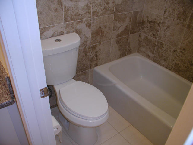 762 High Point Boulevard North, Unit D Delray Beach, FL 33445 - Photo 28 of 43 a white toilet sitting next to a bath tub