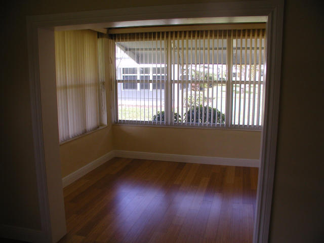 762 High Point Boulevard North, Unit D Delray Beach, FL 33445 - Photo 5 of 43 a view of an empty room with wooden floor and a window