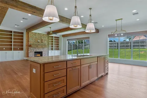 a open kitchen with a sink chandelier and wooden floor