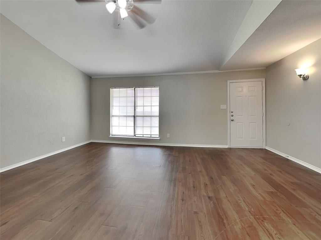 7621 Pebble Beach Drive Rowlett, TX 75088 - Photo 3 of 20 an empty room with wooden floor chandelier fan and windows