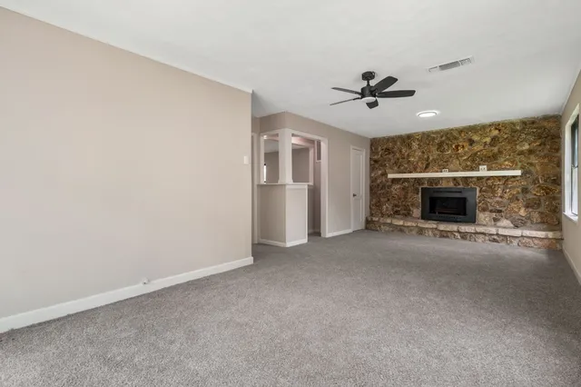 an empty room with fireplace and windows