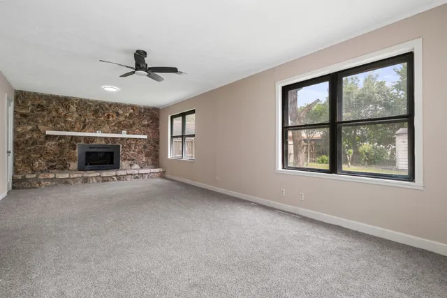 a big room with windows and fireplace