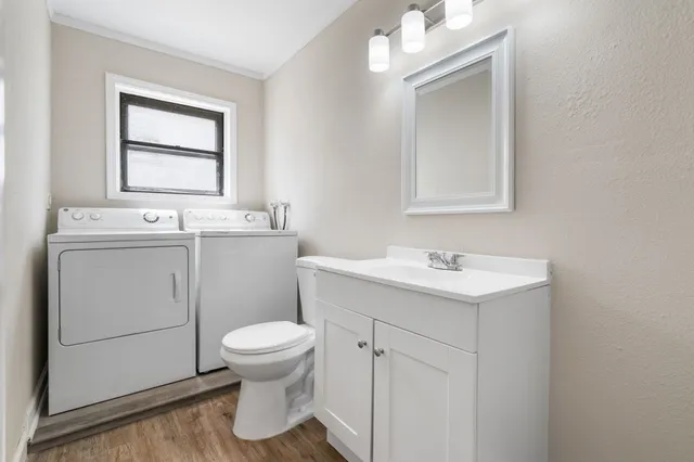 a bathroom with a sink toilet and window