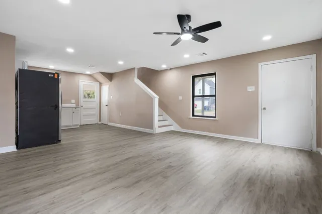 a view of a livingroom with a ceiling fan & wooden floor