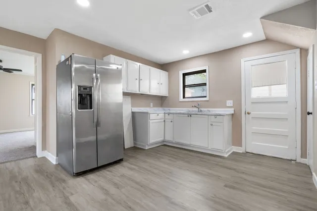 a kitchen with granite countertop a refrigerator and a sink
