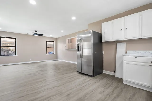 a view of an empty room with a window and wooden floor