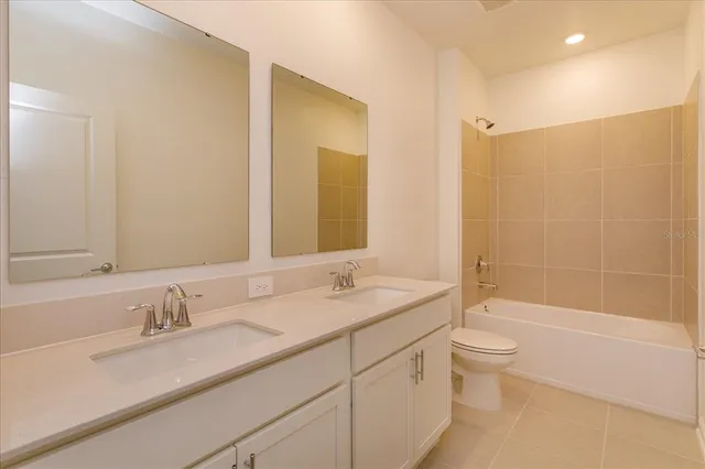 a bathroom with a granite countertop sink a toilet and shower