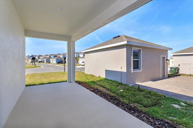 a front view of house with yard and trees in the background