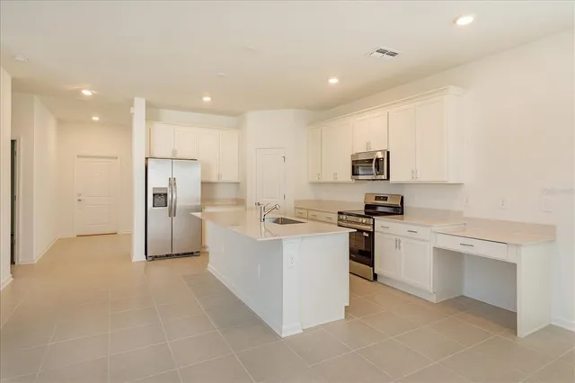 a kitchen with stainless steel appliances a refrigerator stove top oven and sink