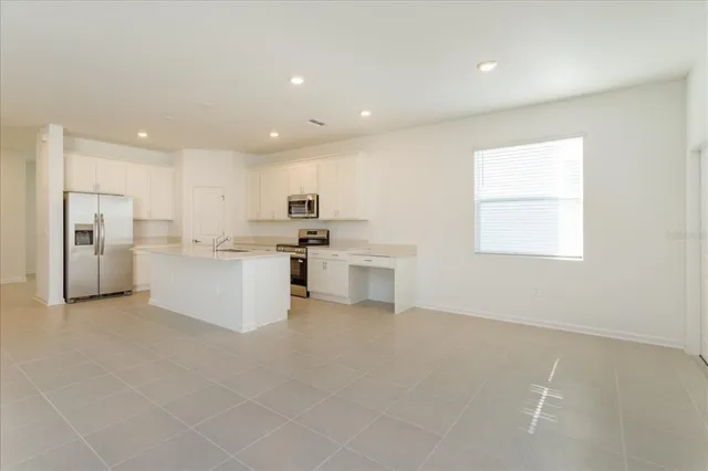 a kitchen with stainless steel appliances a refrigerator sink and cabinets