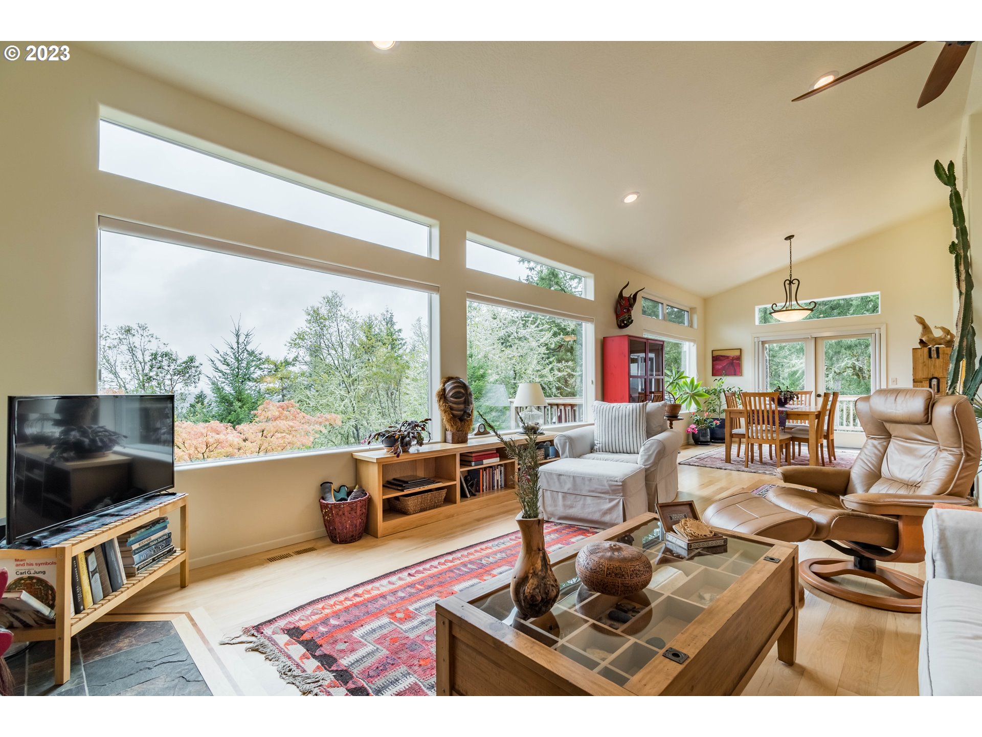 84984 Appletree Drive Eugene, OR 97405 - Photo 9 of 48 a living room with furniture a flat screen tv and a floor to ceiling window