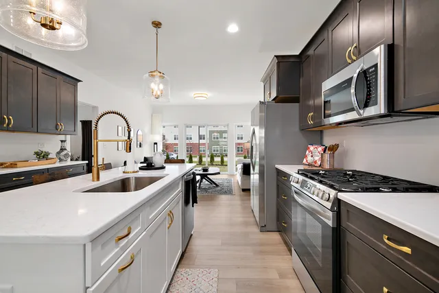 a kitchen with stainless steel appliances granite countertop a sink a stove and cabinets