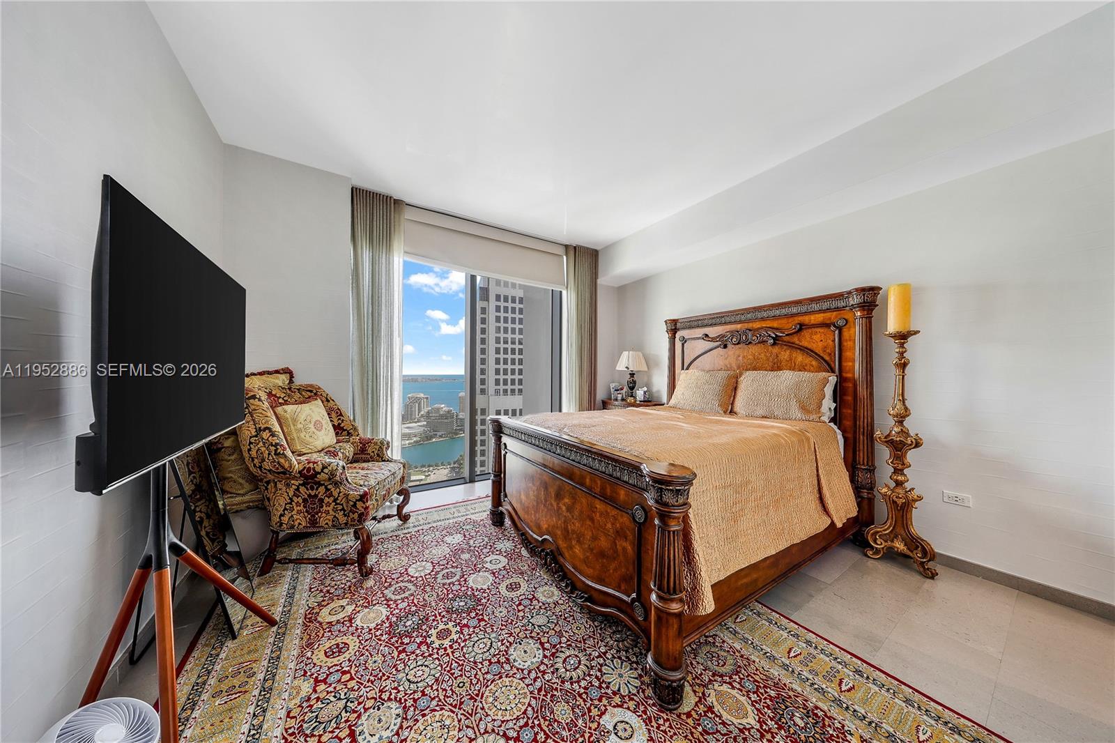 68 Southeast 6th Street, Unit 3309 Miami, FL 33131 - Photo 13 of 25 a bedroom with a bed and a flat screen tv