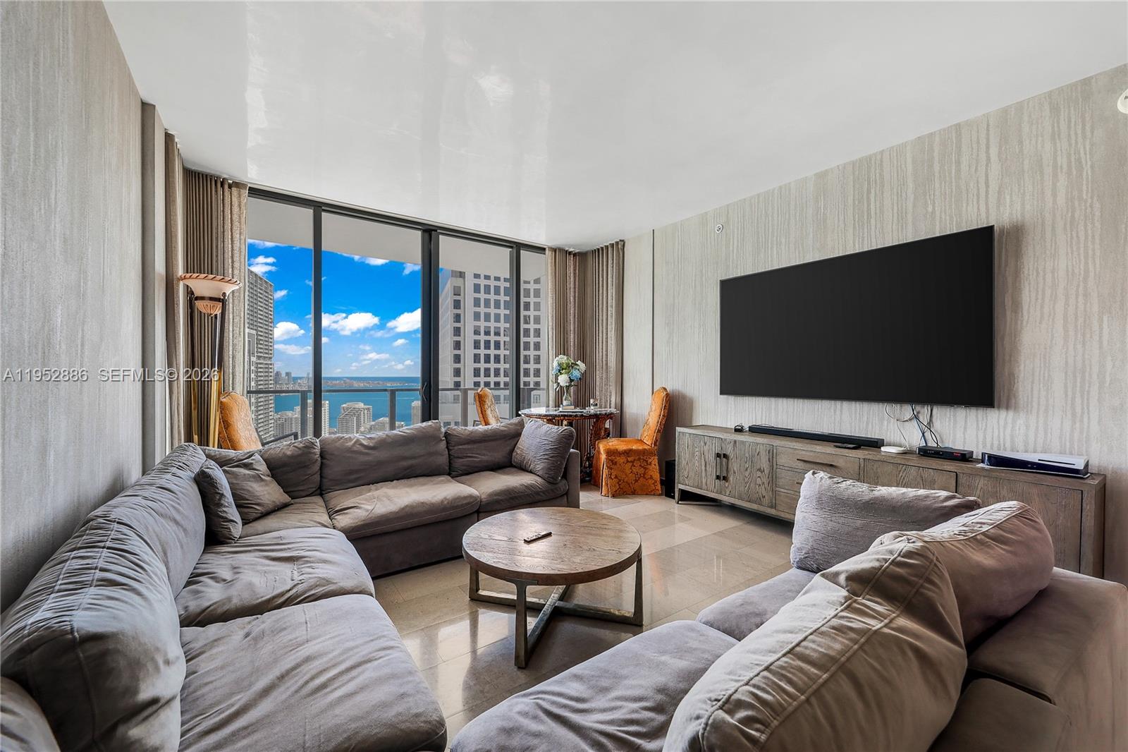 68 Southeast 6th Street, Unit 3309 Miami, FL 33131 - Photo 2 of 25 a living room with furniture and a flat screen tv