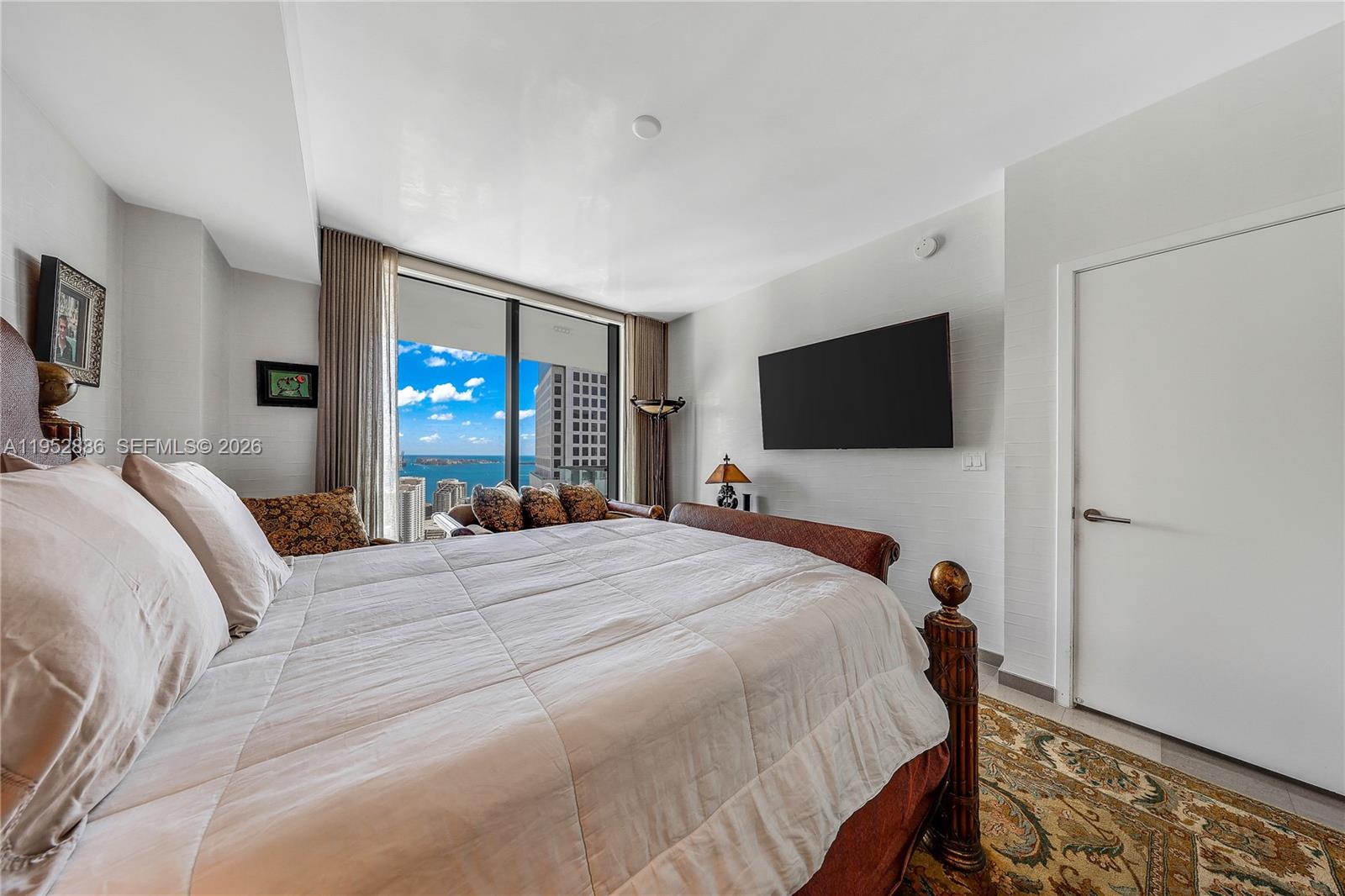 68 Southeast 6th Street, Unit 3309 Miami, FL 33131 - Photo 9 of 25 a bedroom with a bed and a flat screen tv