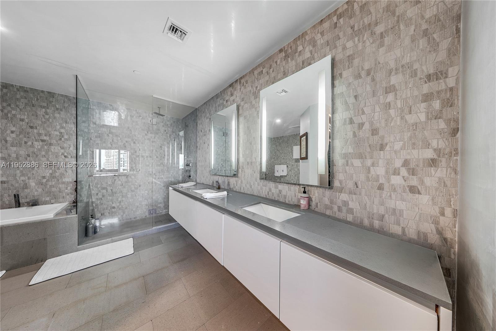 68 Southeast 6th Street, Unit 3309 Miami, FL 33131 - Photo 10 of 25 a bathroom with a double vanity sink a mirror and a bathtub