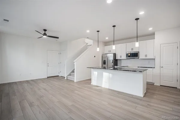 a kitchen with stainless steel appliances sink cabinets and wooden floor