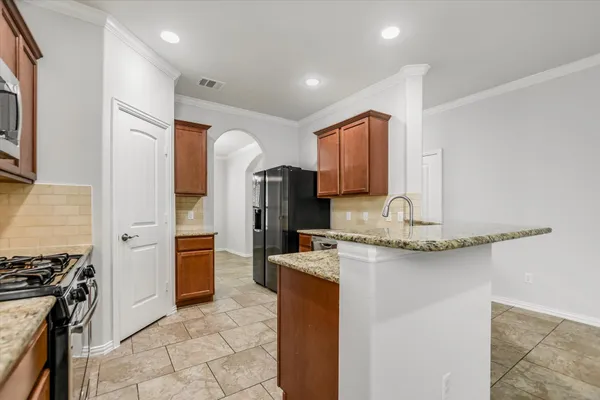 a kitchen with stainless steel appliances granite countertop a sink stove and refrigerator