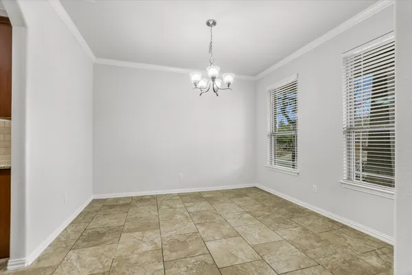 a view of a chandelier in an empty room with a window