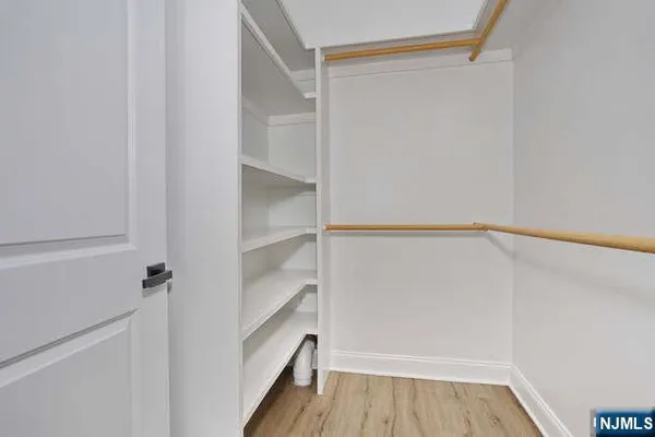 a view of walk in closet with empty racks
