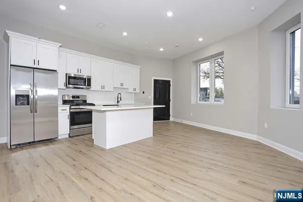 a kitchen with stainless steel appliances a refrigerator sink and cabinets