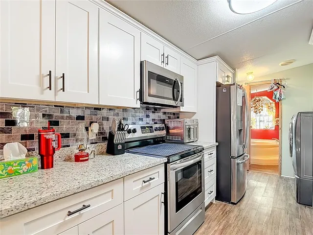 a kitchen with granite countertop a sink stainless steel appliances and cabinets