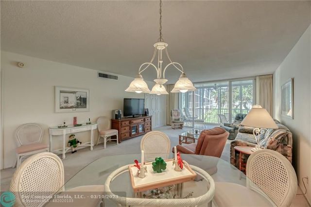a living room with furniture a large window and a chandelier