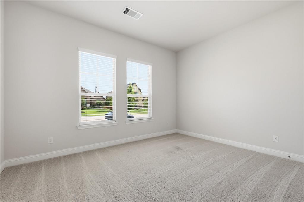 4017 Alpine Street Midlothian, TX 76065 - Photo 25 of 37 Light-filled room featuring two windows with blinds, neutral carpeting, white baseboards, and a ceiling-mounted air vent