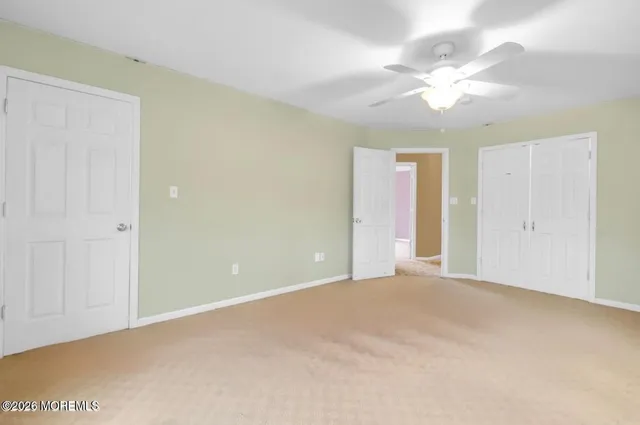 a view of an empty room with a chandelier fan