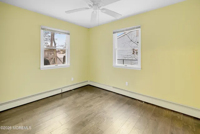 a view of an empty room with a window and a ceiling fan