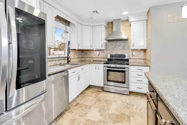 a kitchen with stainless steel appliances granite countertop a stove and a refrigerator