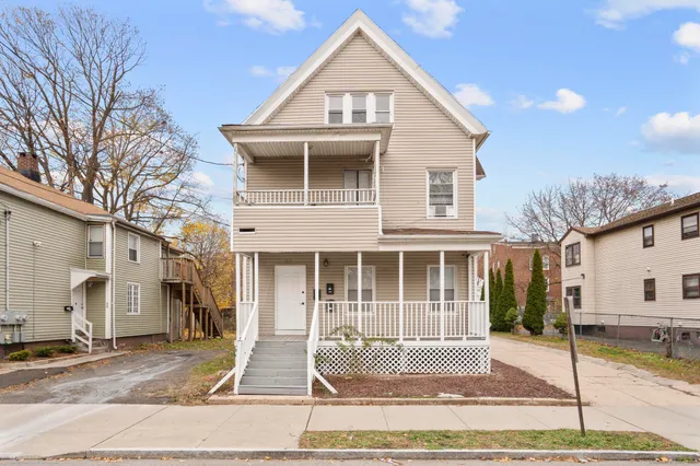 a view of a house with a patio and a yard