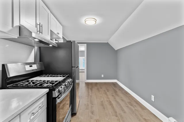 a kitchen with a stove and a wooden floor