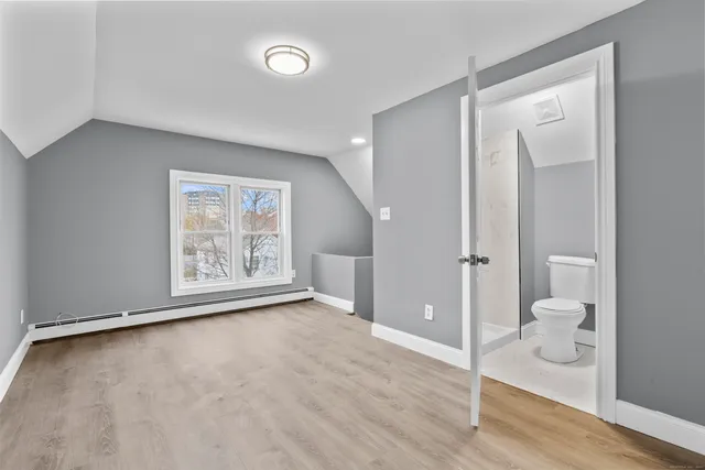 a view of an empty room and room with wooden floor