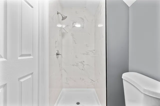 a bathroom with a shower a toilet and sink