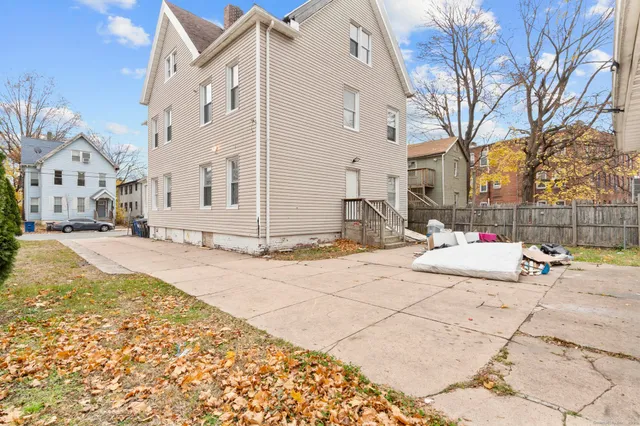 a view of a white house with snow on the side of the road