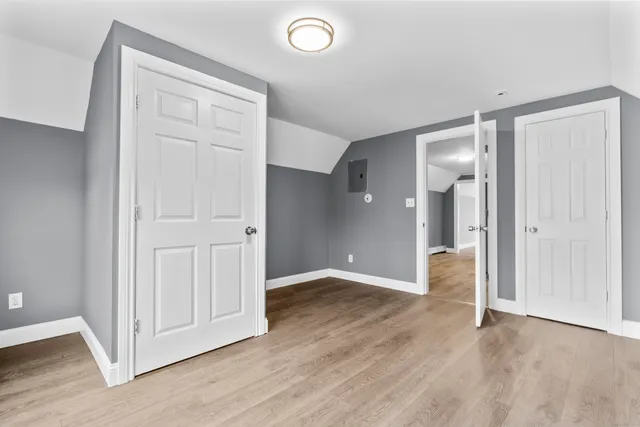 an empty room with wooden floor and closet area